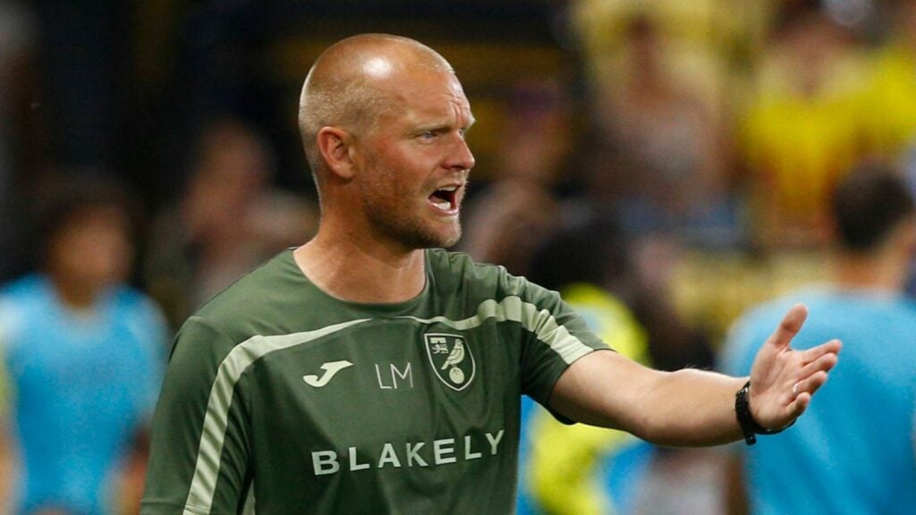 Norwich City manager Liam Manning gesticulates on the touchline during a game.