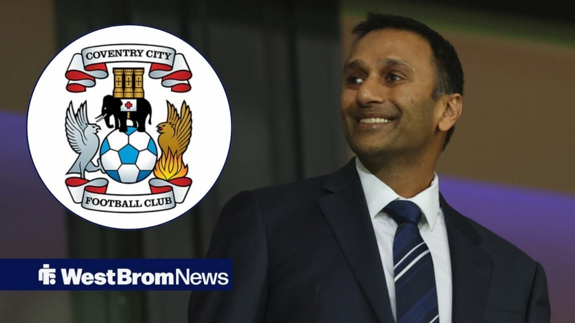 Shilen Patel looking and smiling at the Coventry City badge.