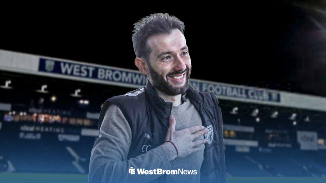 Carlos Corberan smiling in West Brom gear in front of The Hawthorns.